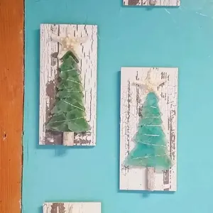 Detailaufnahme handgefertigter Seeglas-Weihnachtsbaum-Deko auf rustikalem Holz