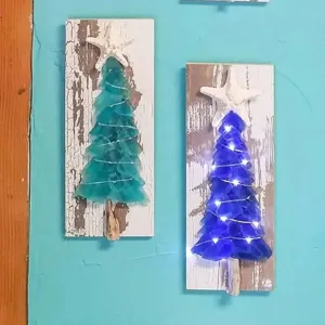 Detailansicht der DIY Seeglas-Weihnachtsbaum-Wanddeko mit Seestern und LED-Leuchten.