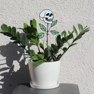 Detailansicht eines kreativen Halloween Totenkopf-Gartensteckers aus Metall im Topf