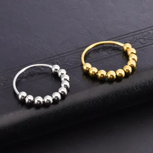 Detailansicht der Ringe aus Edelstahl in Silber und Gold mit beweglichen, polierten Perlen.