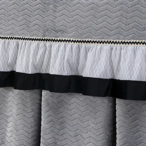 Detalle funda calefactora felpa, tela térmica chevrón gris con volante de encaje blanco.