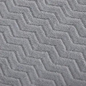 Detalle de primer plano de tela de felpa gris con textura suave y patron de cheveron.
