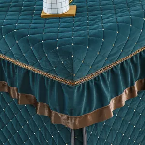Thickened winter heating table cover detail view, green quilted fabric with brown ruffles.