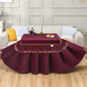 Vue détaillée de la housse de table chauffante matelassée épaisse bordeaux avec jupe à volants.