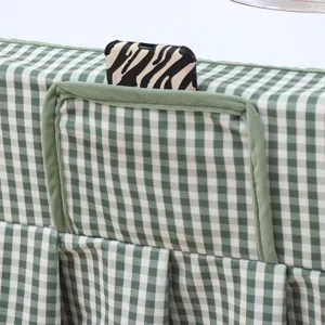 Green and white plaid table cover detail with handy storage pocket and soft fleece material.