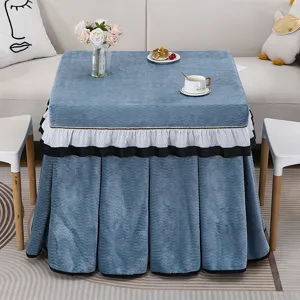 Vista detallada de la funda de mesa cuadrada de felpa azul con volantes y estilo acogedor.