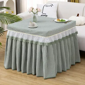 Detailed view of green and white checkered table cover with delicate lace ruffles for home decor.