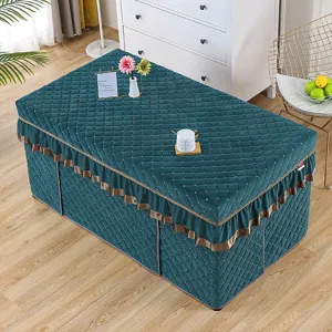 Detailed view of a thick quilted dark green heating table cover with elegant brown ruffles for winter.