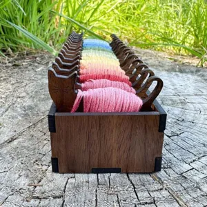 Detailansicht von katzenförmigen Holzspulen mit bunten Regenbogen-Stickfäden im Set