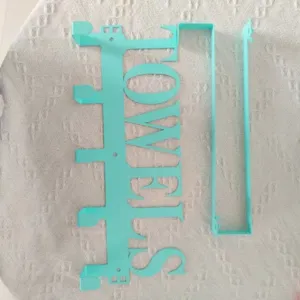 Detailed macro view of the turquoise metal over-the-door towels hook with lettering