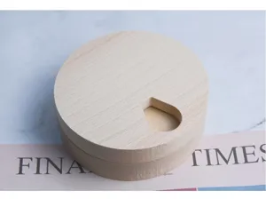 Vista superior de una caja de pastillas redonda de madera de haya con abertura de gota
