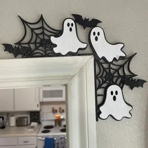 Detailed view of wooden Halloween ghost door frame decoration on a white mirror