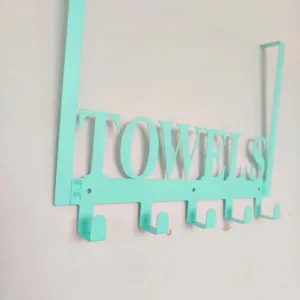 Close-up detail of mint green metal over-the-door hook rack with TOWELS cutout design