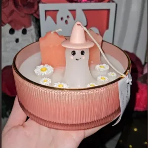 Λεπτομέρεια ροζ κεριού φάντασμα Halloween με ταφόπλακες και μαργαρίτες σε γυάλινο μπολ