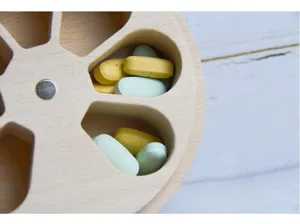 Vista detallada de un organizador de pastillas de madera de haya con siete ranuras.