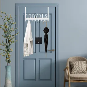 White iron over-the-door towel rack with TOWELS design holding various items