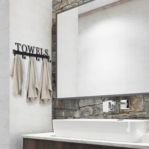 Modern black iron TOWELS wall hook rack mounted in a stylish contemporary bathroom