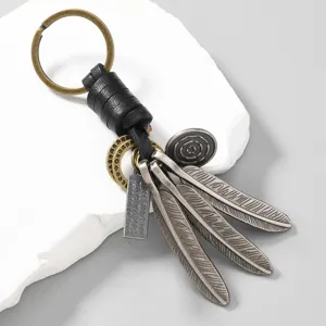 Vintage leather keychain with silver alloy feathers and engraved metal tag detail