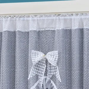 Close-up of double layer lace door curtain with bow detail, elegant partition fabric.