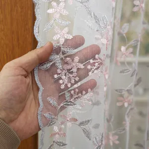 Detailed close-up shot of floral embroidered lace sheer curtain fabric displaying delicate texture.