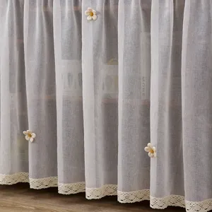 Detalle de cortina de armario transparente con borde de encaje delicado y margaritas.