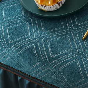 Dark teal velvet tablecloth detail shot, luxury quilted geometric pattern table cover.