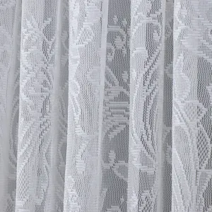 Detailed close-up of white lace curtain fabric, showing delicate floral woven texture.