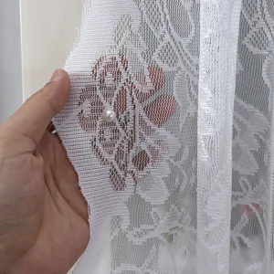 White lace curtain detail showing delicate floral pattern and translucent texture with pearl.
