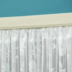Close-up detail of white lace curtain featuring delicate floral pattern for home decor.