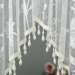 Exquisite white lace sheer curtain detail featuring elegant hanging faux pearls for room decor.