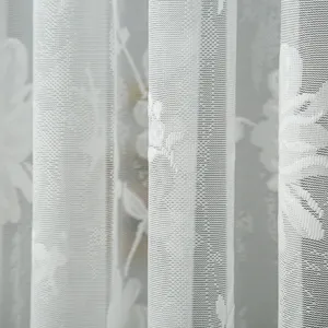 Detailed view of white lace curtain showing delicate mesh texture and floral pattern for home decor.