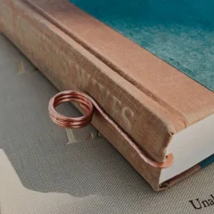 Primo piano di un segnalibro ad anello in rame fatto a mano in un libro d'epoca vintage