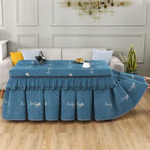 Detailansicht der verdickten Pluesch-Rechteck-Tischabdeckung fuer Heiztoefen mit elegantem blauen Rock.