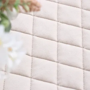 Detail van de verdikte fleece gewatteerde tafelbedekking met een zacht ruitpatroon.