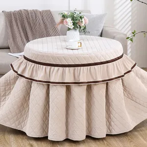 Gedetailleerd overzicht van de gewatteerde ronde tafelhoes met dik fleece en elegante volant.