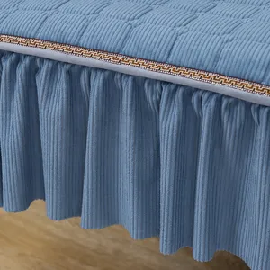 Detailansicht des blauen gesteppten Stoffbezugs mit Plissierrock und Zierborte.