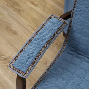 Nahaufnahme des blauen gesteppten Stuhlkissen-Pads mit klassischem Muster am Armlehnen.