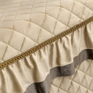 Detailed view of quilted winter heating table cover with elegant gold trim and ruffled edge.