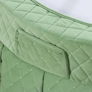 Gedetailleerd overzicht van de groene ronde gewatteerde verwarmingstafelhoes met zachte pluche.