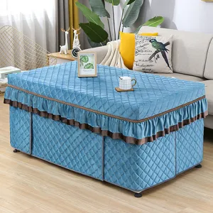 Detail view of blue quilted heating table cover with elegant ruffles, winter warmth.