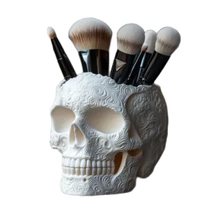 Vista detallada del porta brochas de calavera blanca con intrincados patrones florales