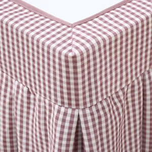 Close-up detail of pink and brown gingham checkered table cover fabric texture and pleats.