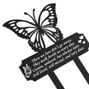 Detailansicht eines schwarzen Schmetterling-Gartensteckers mit weißem Gedenktext