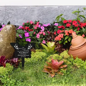 Gedenkpfahl Schmetterling für den Garten mit Mitgefühlstext in blühender Umgebung