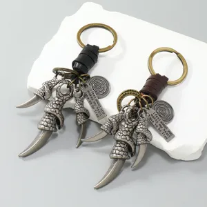 Macro detail showing vintage eagle claw keychains with leather cord and engraved charms