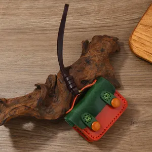 Dettaglio macro di una custodia AirPods vintage in pelle fatta a mano verde e rossa