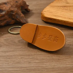 Détail d'un porte-clés en cuir fait main en forme de chaussure avec inscription embossée