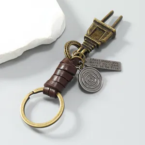 Close-up of vintage alloy power plug keychain with braided cowhide leather accents