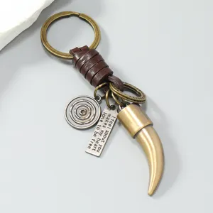 Gros plan d'un porte-clés vintage en bronze avec dent de bête et cordon en cuir