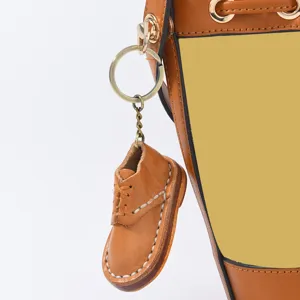 Détail du porte-clés miniature en cuir fait main en forme de chaussure avec anneau